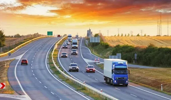 Multi-lane state highway carrying light traffic through open countryside at dusk